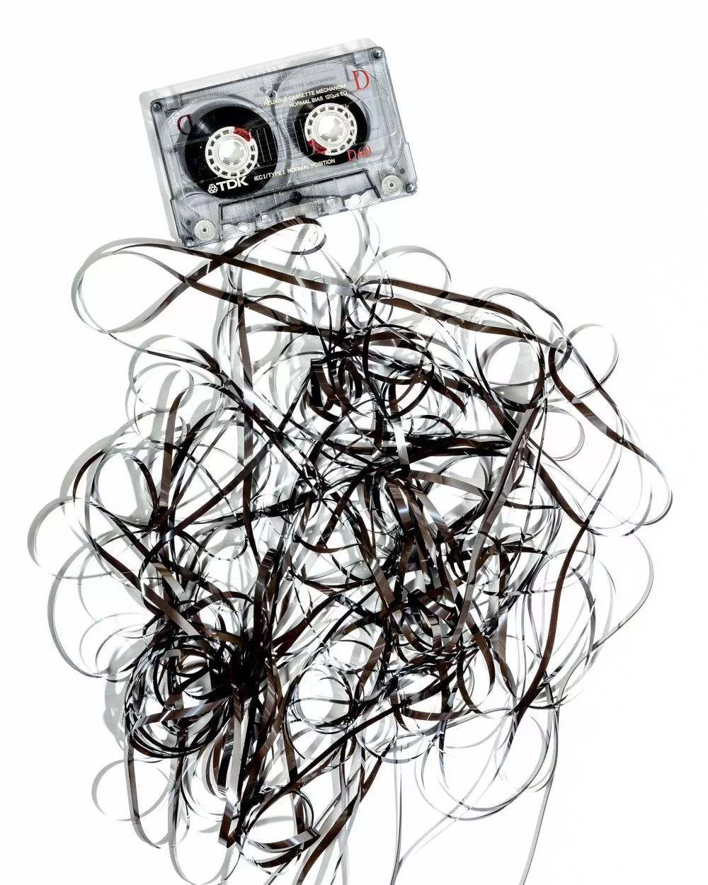 Une cassette audio avec la bande magnétique déroulée et enchevêtrée.