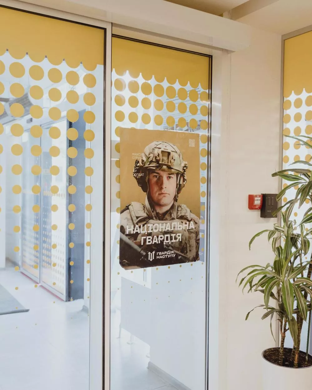 Un poster de la Garde nationale est affiché sur une porte vitrée, montrant un soldat en uniforme.