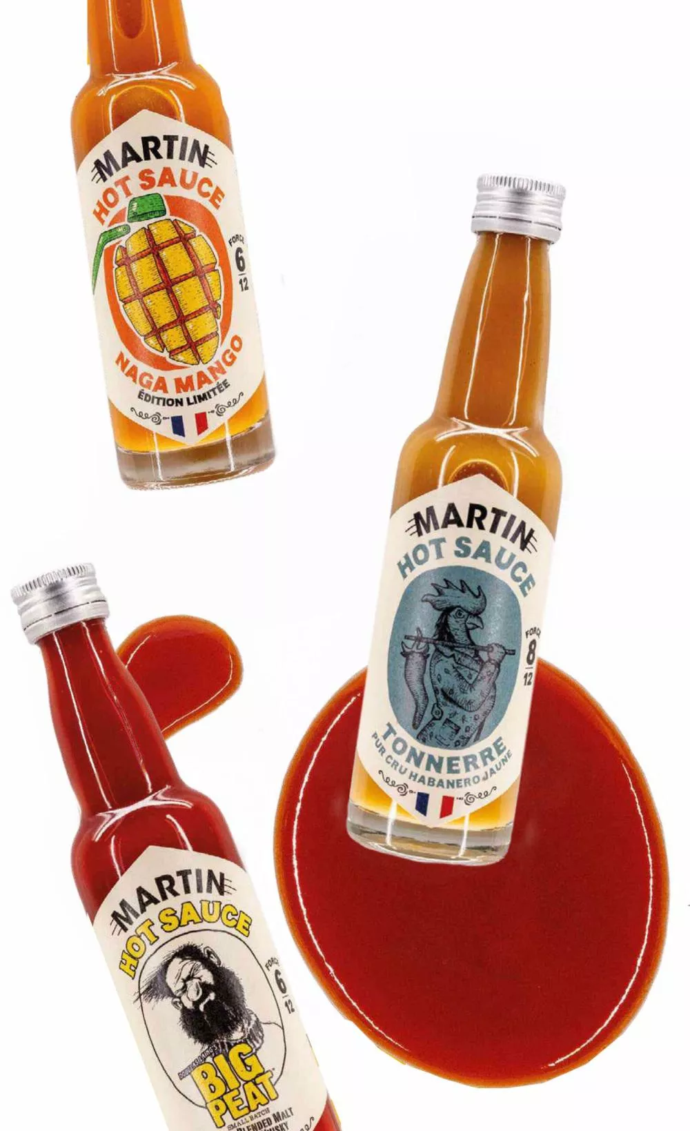 Trois bouteilles de sauce piquante "Martin Hot Sauce" avec les variétés "Naga Mango", "Tonnerre" et "Big Peat". Les bouteilles sont inclinées et entourées de sauce rouge.