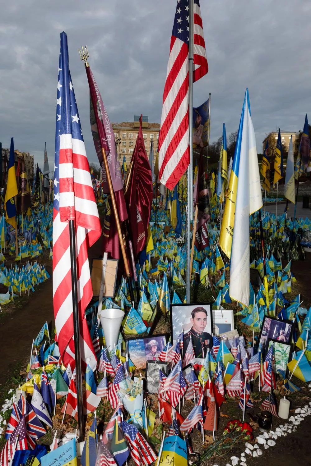 Un mémorial avec de nombreuses drapeaux, dont des drapeaux américains et ukrainiens, entourant des portraits de soldats.