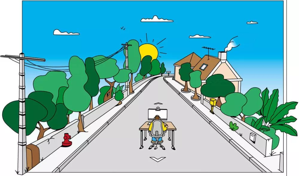 Une personne est assise à un bureau au milieu d'une route bordée d'arbres et de maisons, sous un ciel bleu avec un soleil brillant.