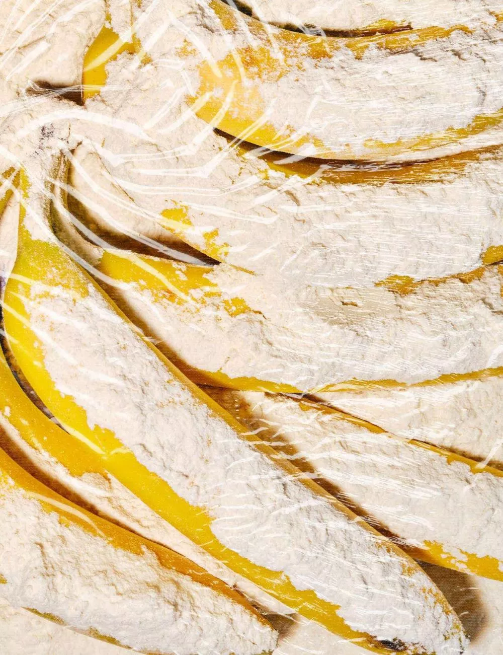 Des bananes recouvertes de farine sous un film plastique.