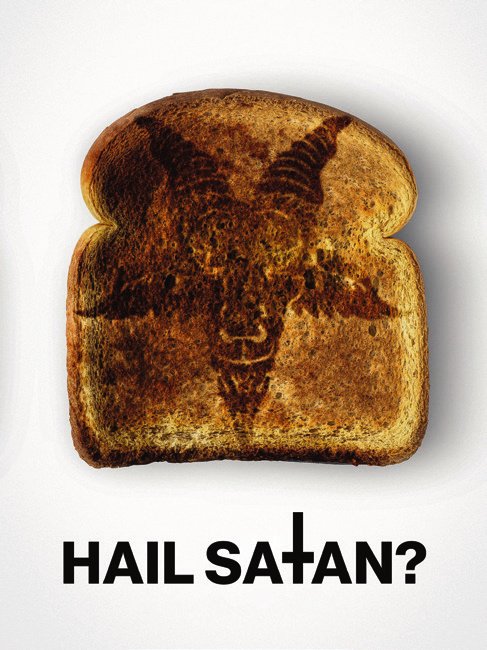 Une tranche de pain grillé avec une image de tête de bouc grillée dessus, accompagnée du texte "HAIL SATAN?" en dessous.