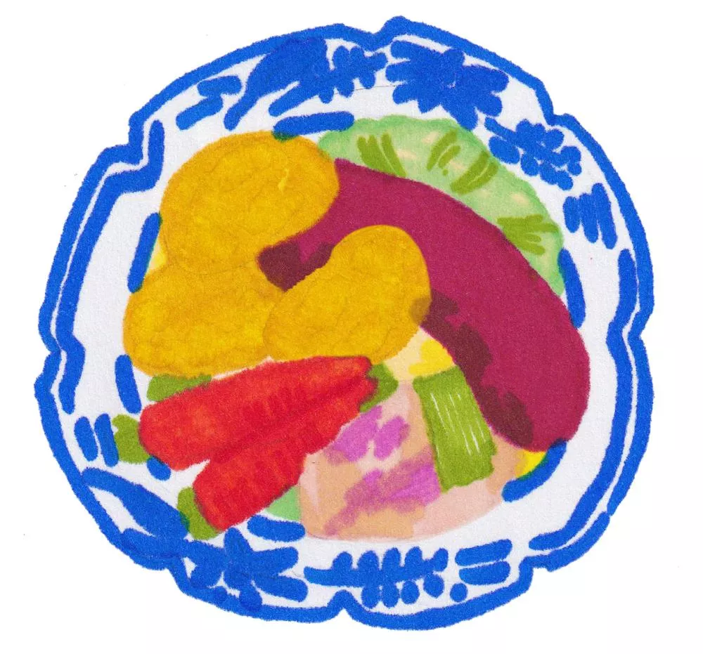 Une assiette colorée contenant des légumes variés, dont des carottes, des pommes de terre, et un légume violet. L'assiette a un motif bleu sur le bord.