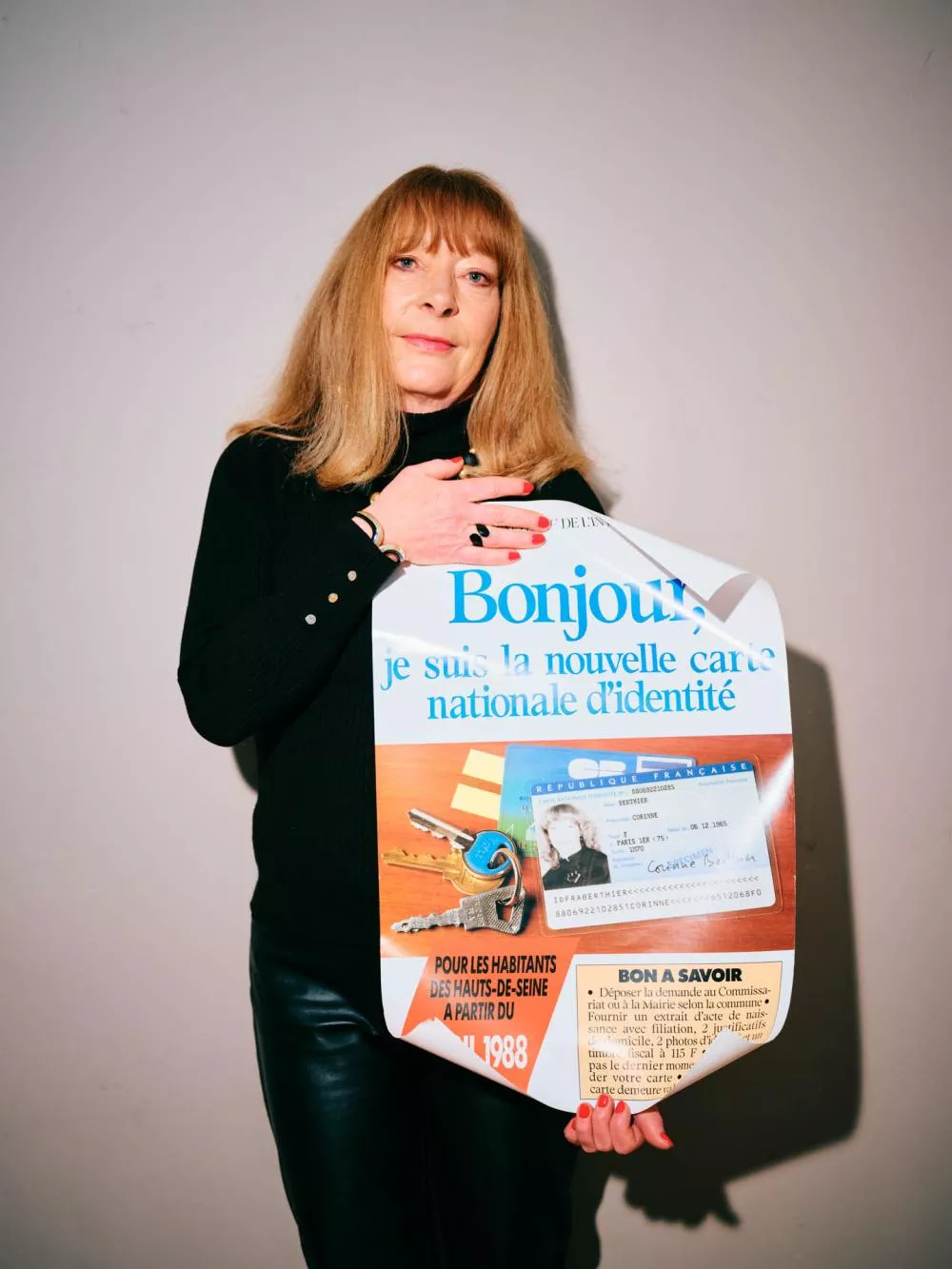 Une femme tient une affiche annonçant la nouvelle carte nationale d'identité pour les habitants des Hauts-de-Seine à partir de mai 1988. L'affiche inclut une image de la carte d'identité et des instructions pour l'obtenir.