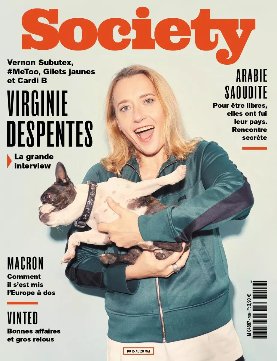 Une femme souriante tient un chien dans ses bras sur la couverture du magazine "Society". Les titres mentionnent une grande interview de Virginie Despentes, des articles sur l'Arabie Saoudite, Macron et Vinted.