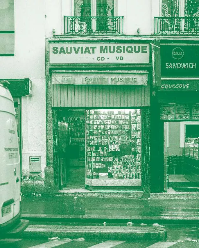 Une boutique nommée "Sauviat Musique" spécialisée dans les CD et VD, située à côté d'un magasin de sandwichs.