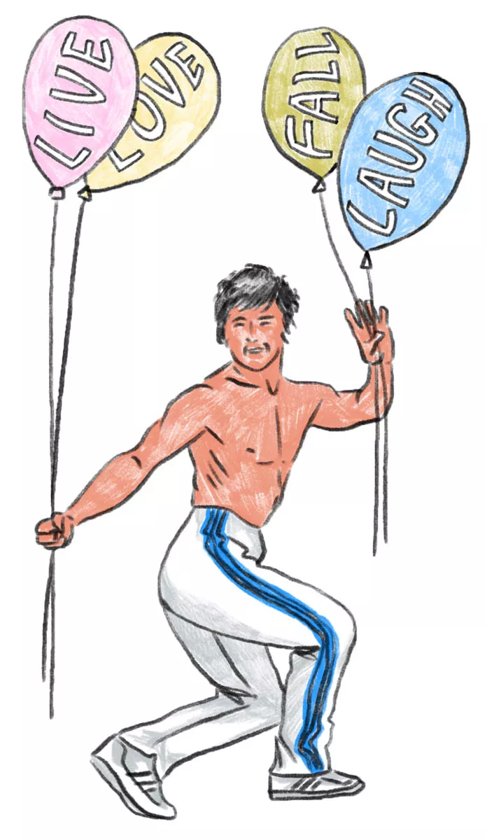 Un homme torse nu en pantalon de sport blanc avec des bandes bleues tient quatre ballons colorés avec les mots "LIVE," "LOVE," "LAUGH," et "FALL."