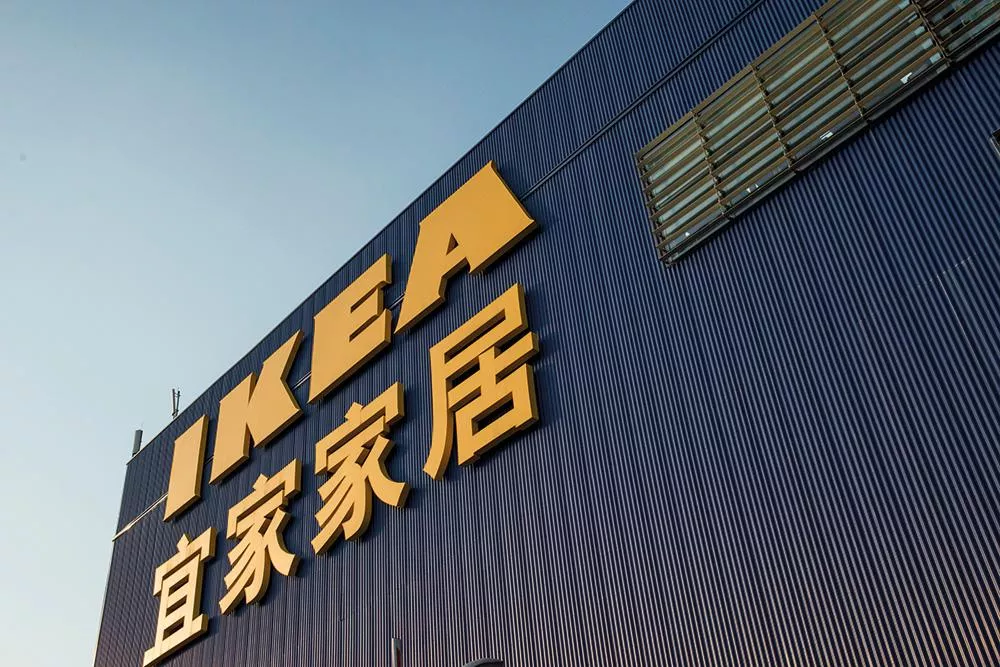 Un bâtiment avec le logo d'IKEA en lettres jaunes sur un fond bleu, accompagné de caractères chinois.
